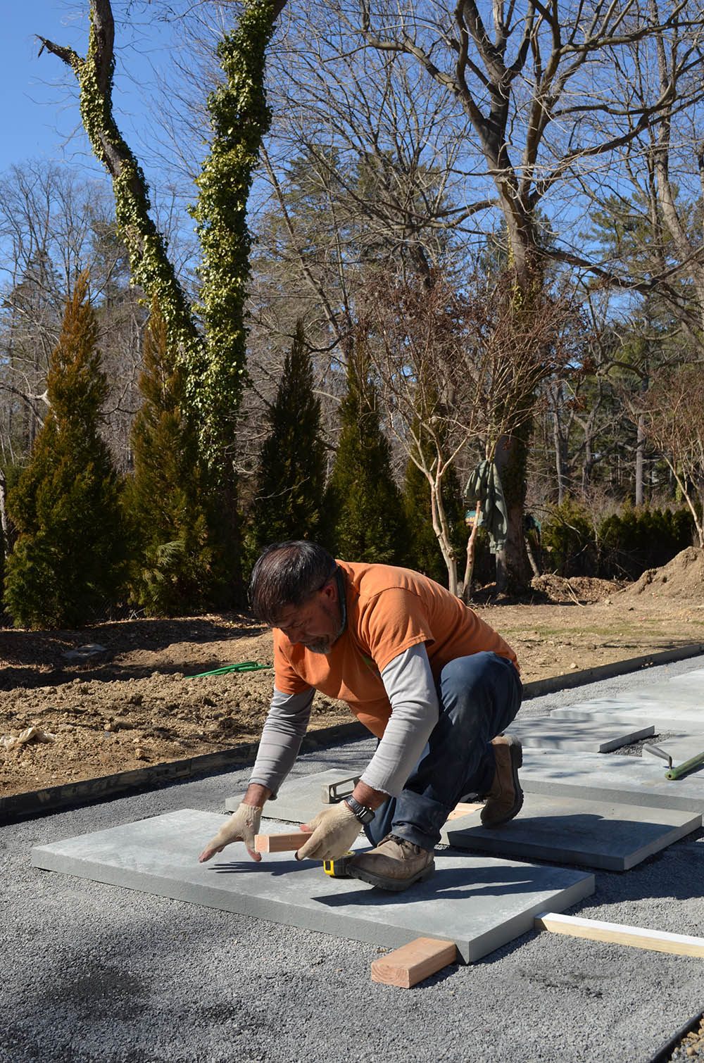 landscape worker laying down pavers